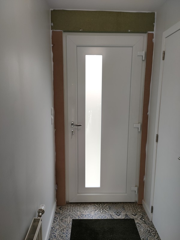 Porte d’entrée PVC Blanc / Panneau Volma 766 / Poignée sur rosace / Paumelle 3D (Renforcée) / Ebrasement intérieur réalisé en Medium